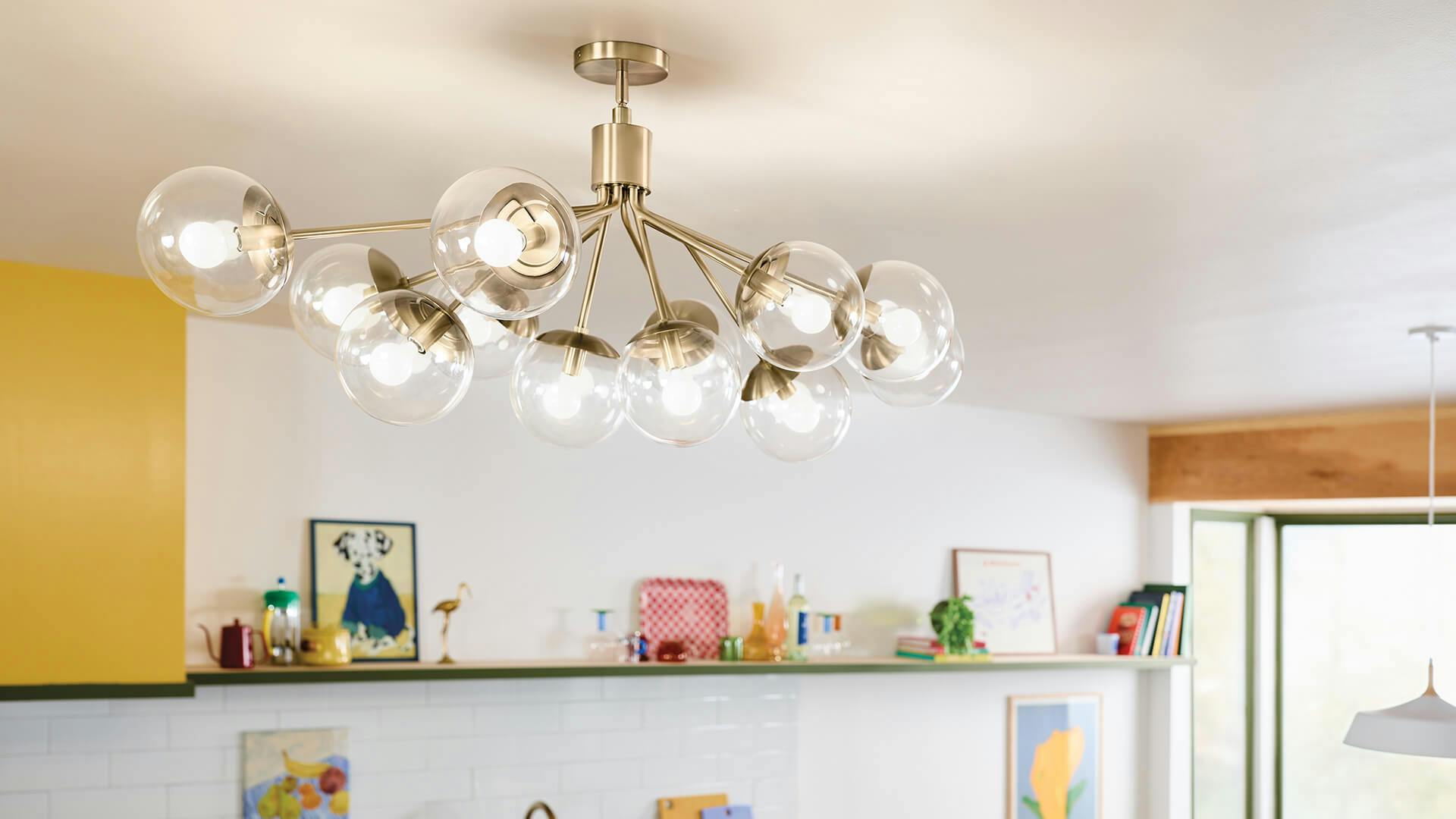 White kitchen with yellow accents and a 12-light Silvarous chandelier in champagne bronze hanging from cieling