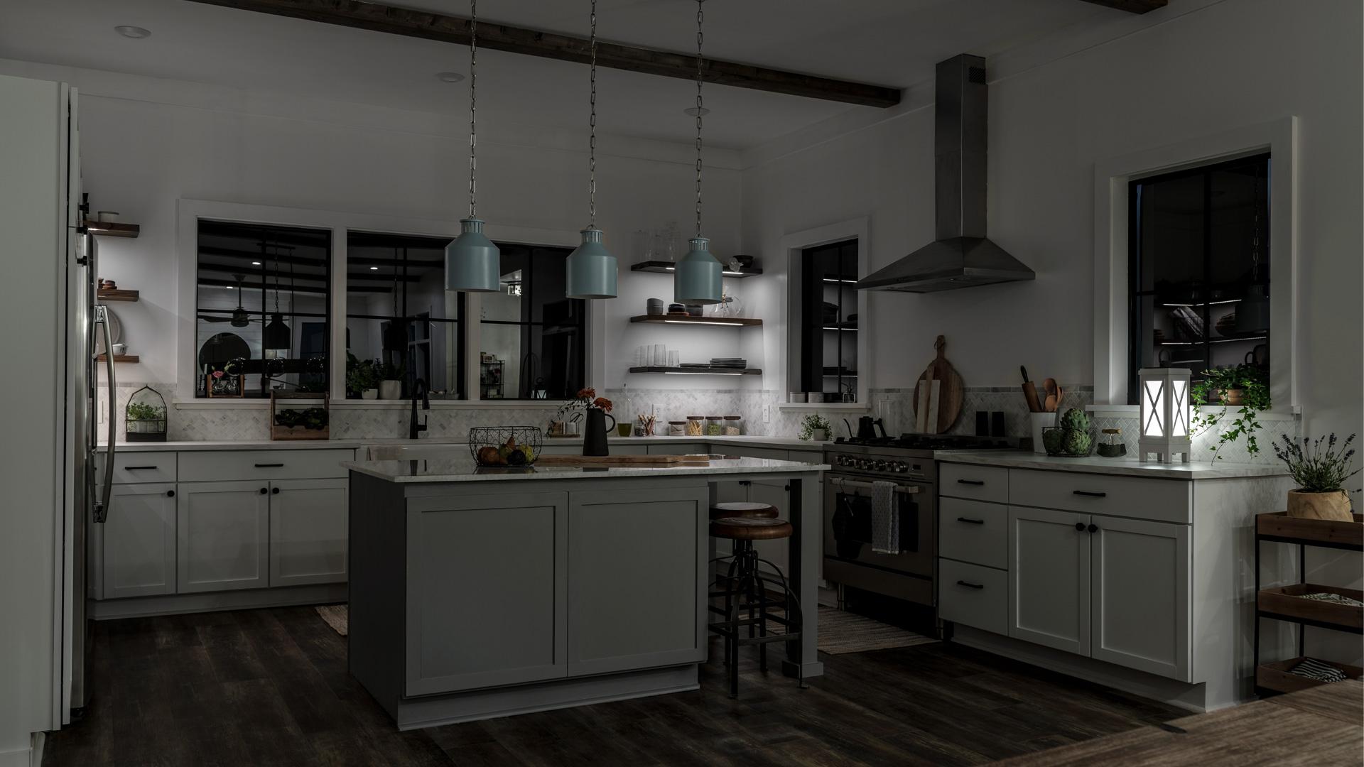 A kitchen with tape lights, shelf lighting, kicktoe lighting, and Montauk pendants, with just the shelf lights turned on at night