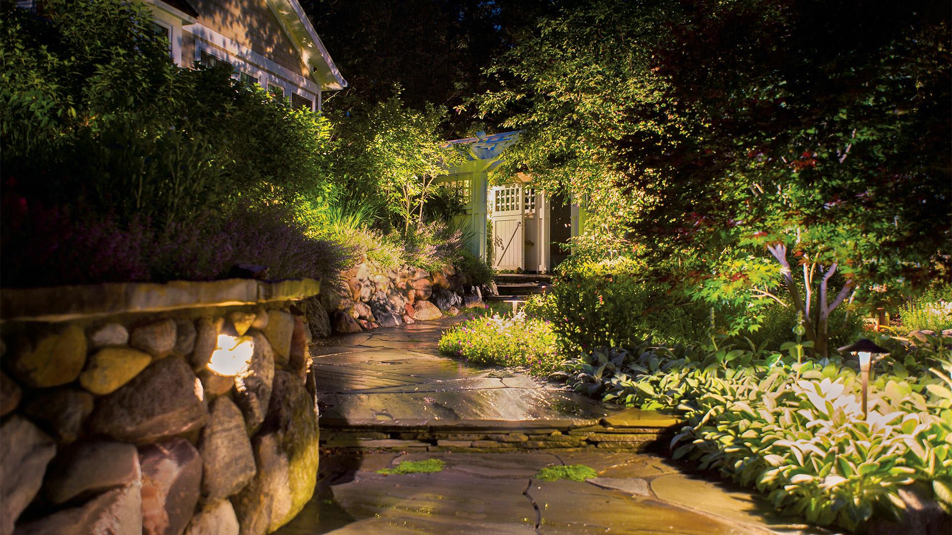 Evening walkway up to a cottage style home with variety of path lights