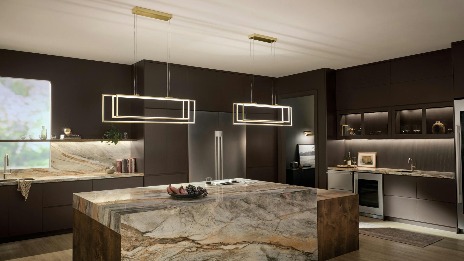 Modern luxe kitchen with marble counters featuring 2 champagne gold Jestin chandeliers 