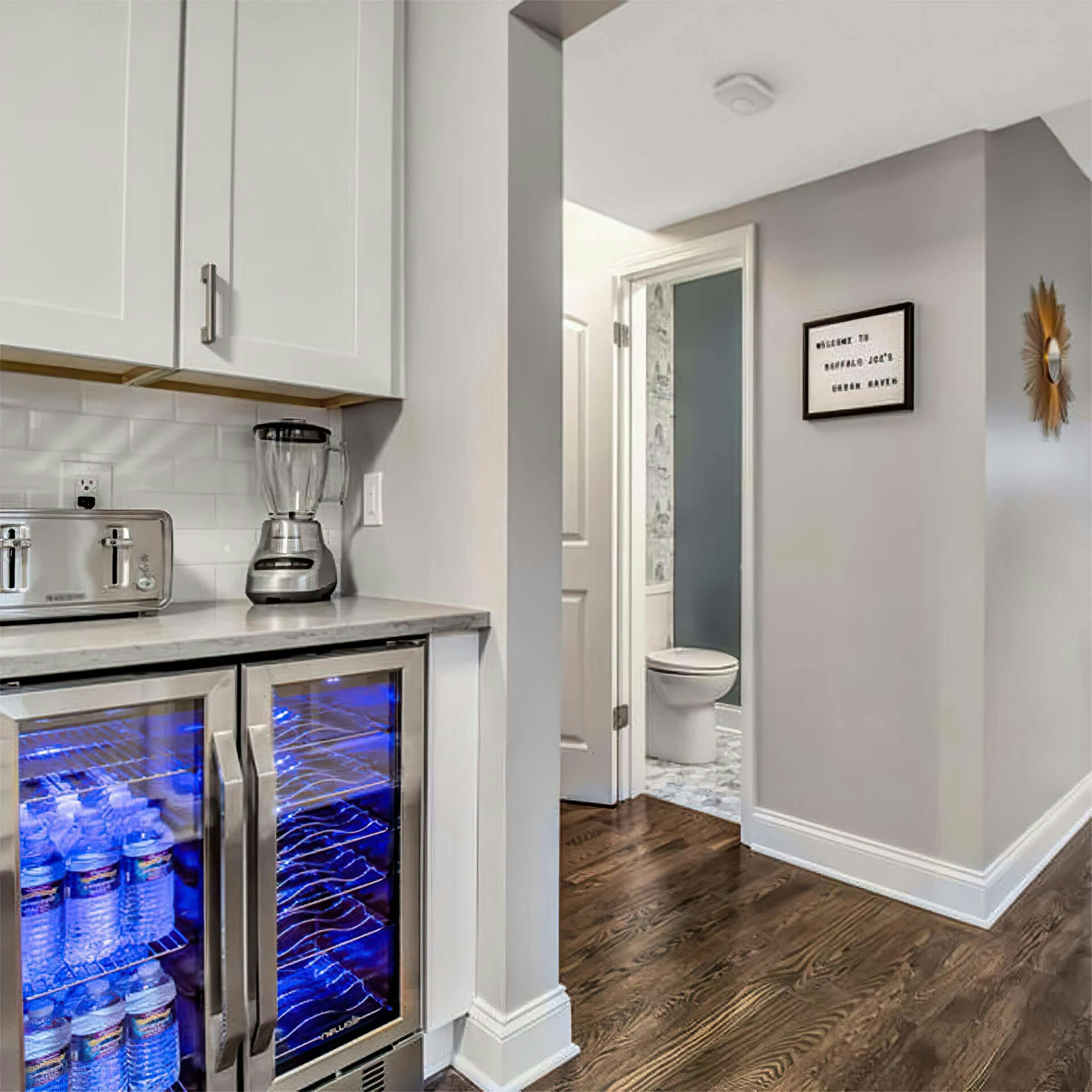 Wine refrigerator and doorway to a half bath 