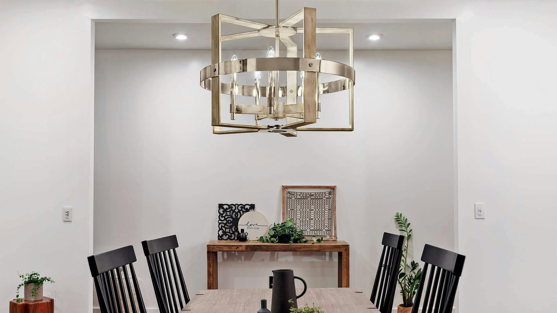 White-walled living room with a Peyton chandelier shining above the dining table and mounted lights in the ceiling