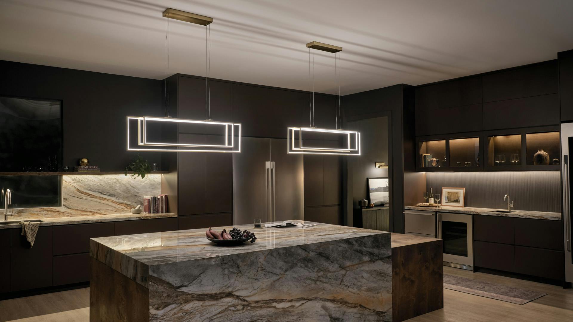 Modern luxe kitchen with marble counters featuring 2 champagne gold Jestin chandeliers 