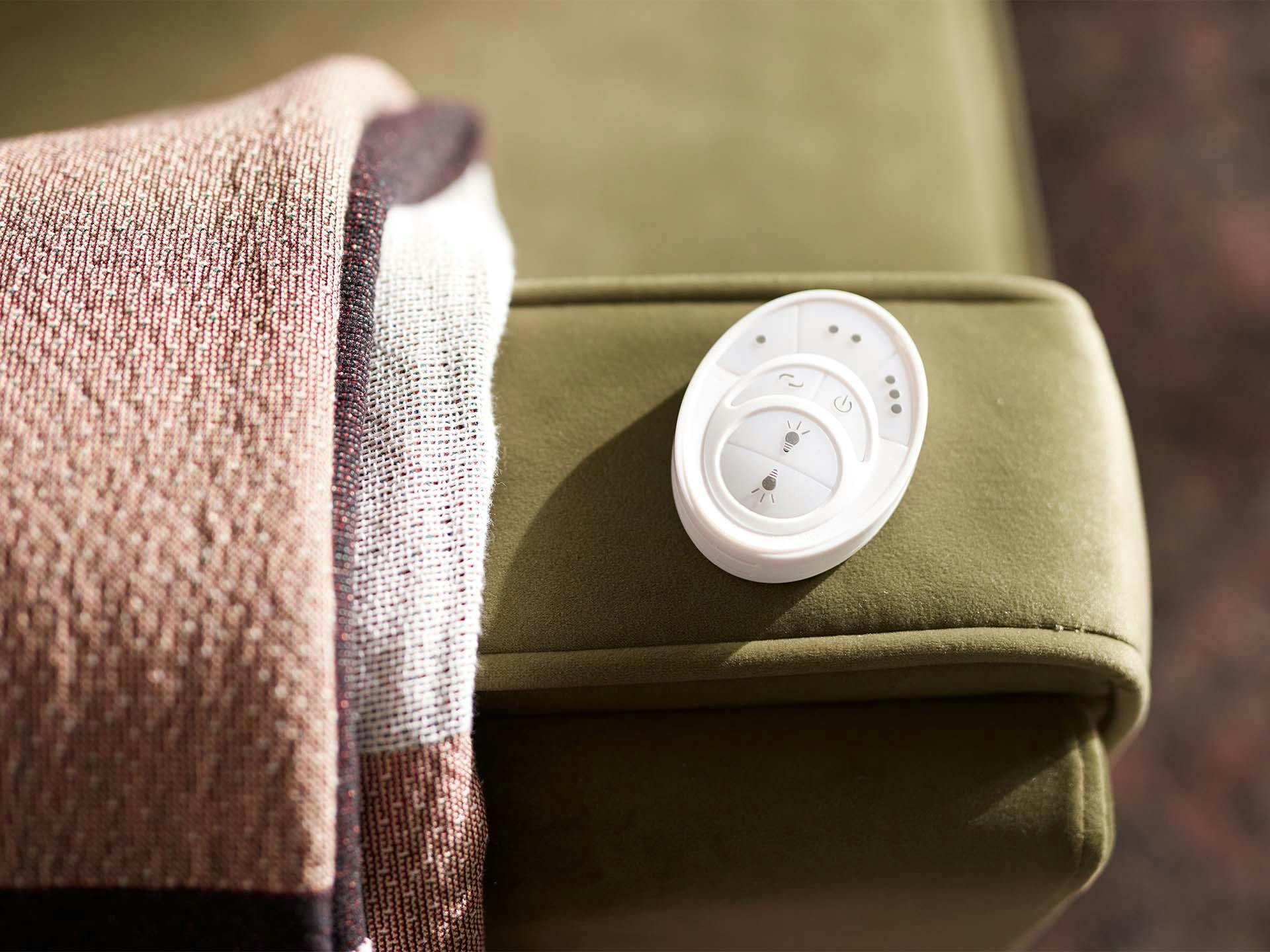 Living Salvo ceiling fan remote on the arm of a couch.