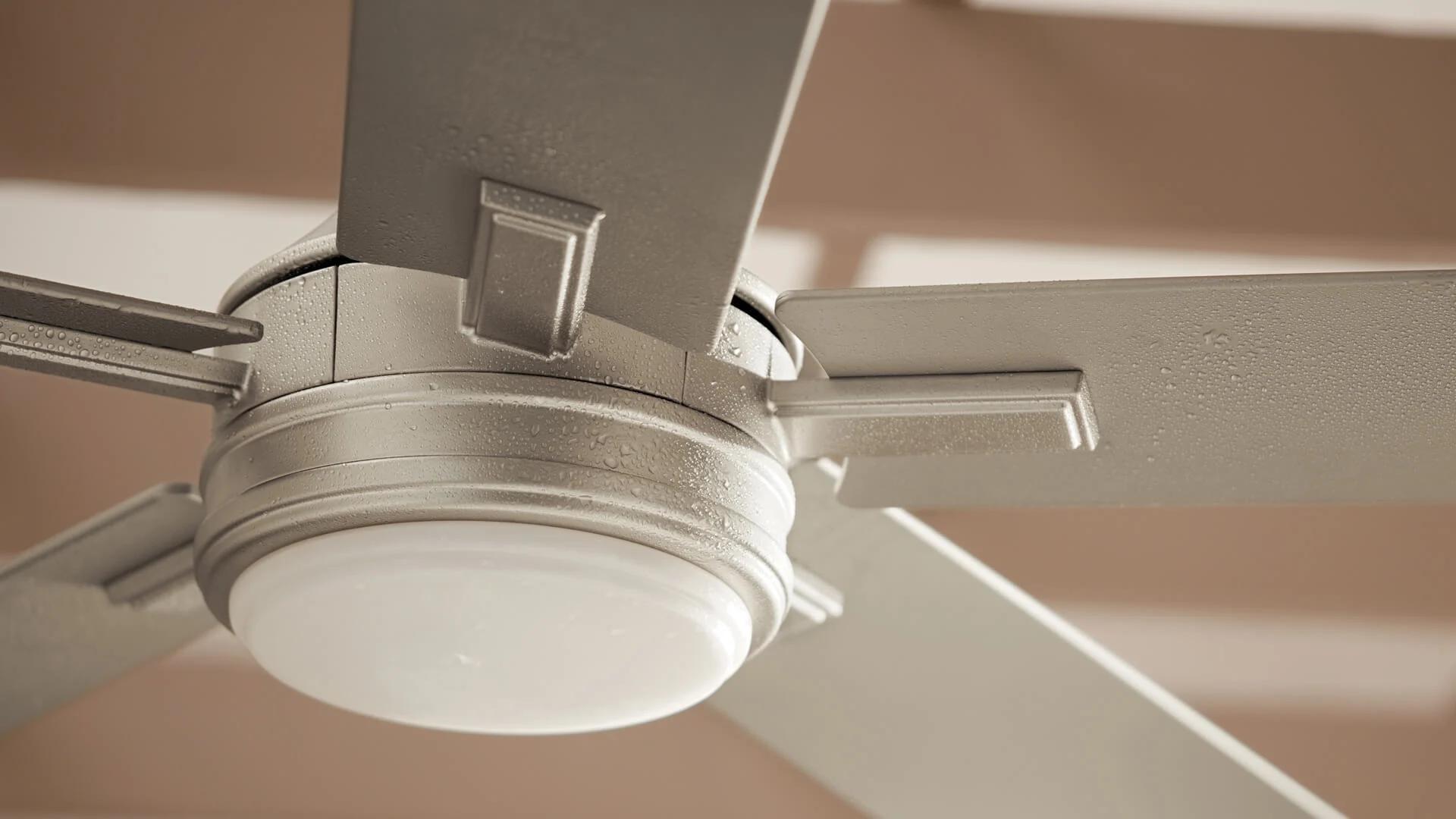 Close up of a tide ceiling fan with a light amount of moisture droplets on the blades.