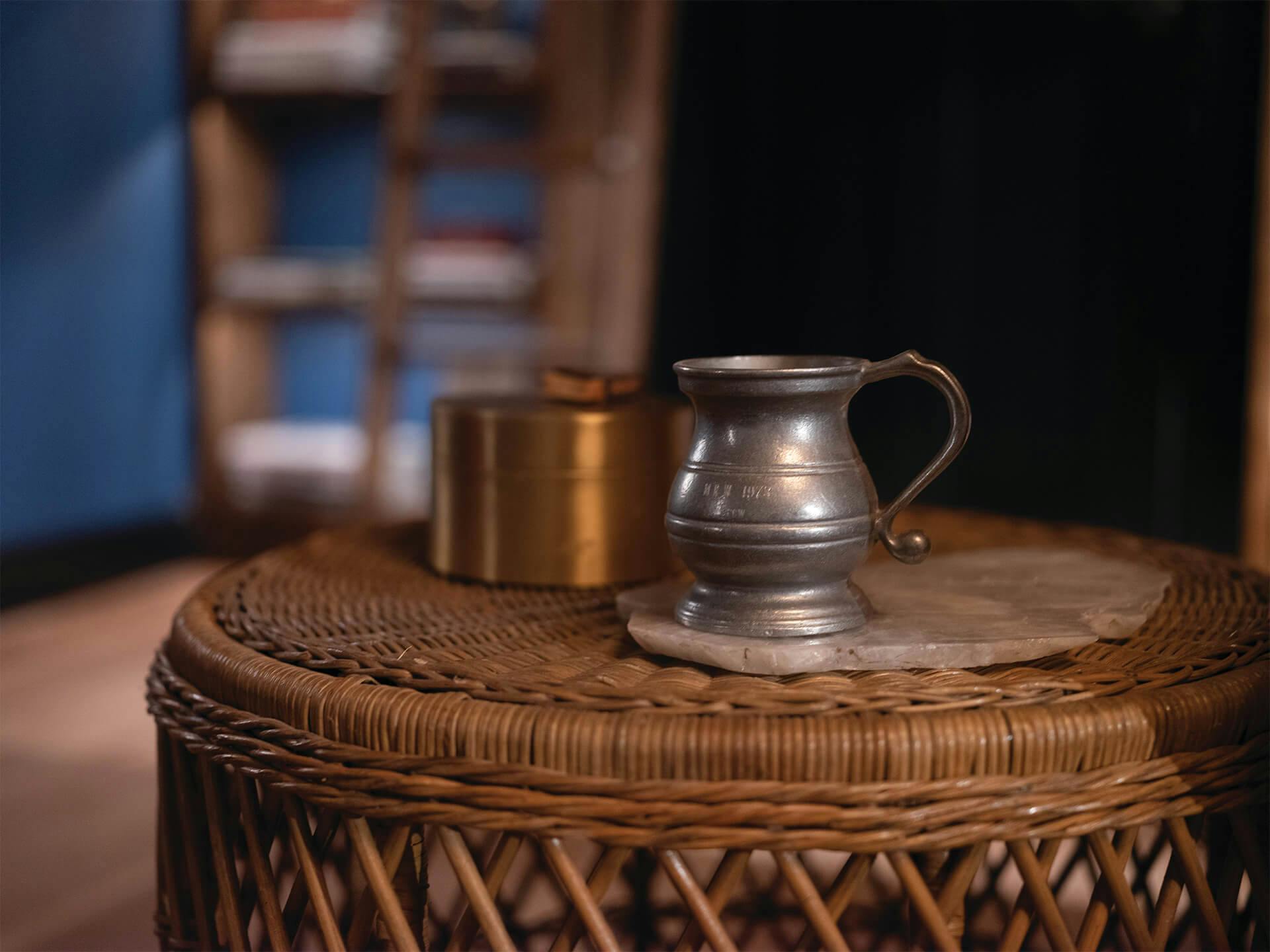 A pitcher and cup on a woven basket