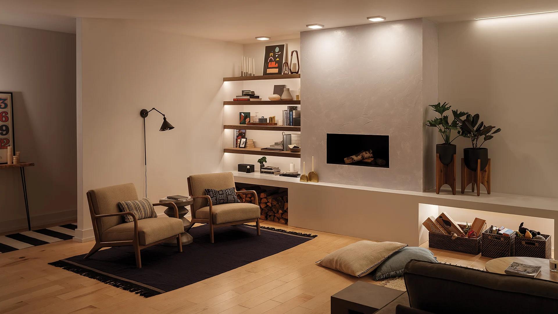 Living room at night with overhead ceiling lights and ellerbeck wall sconce with a reading nook.