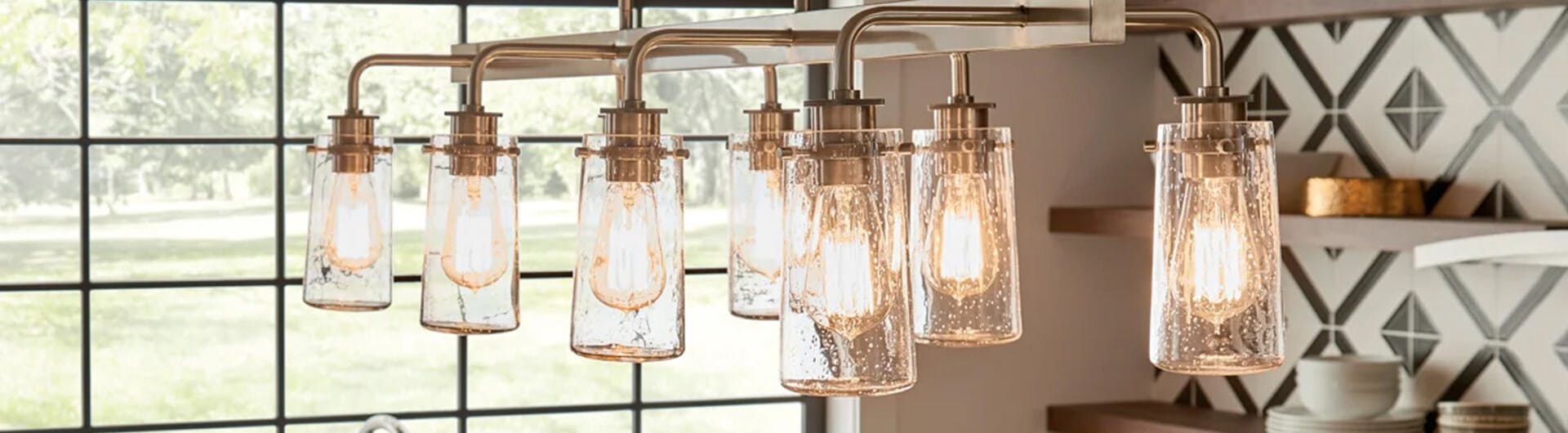 Close up of a Braelyn chandelier in bronze hanging in a kitchen