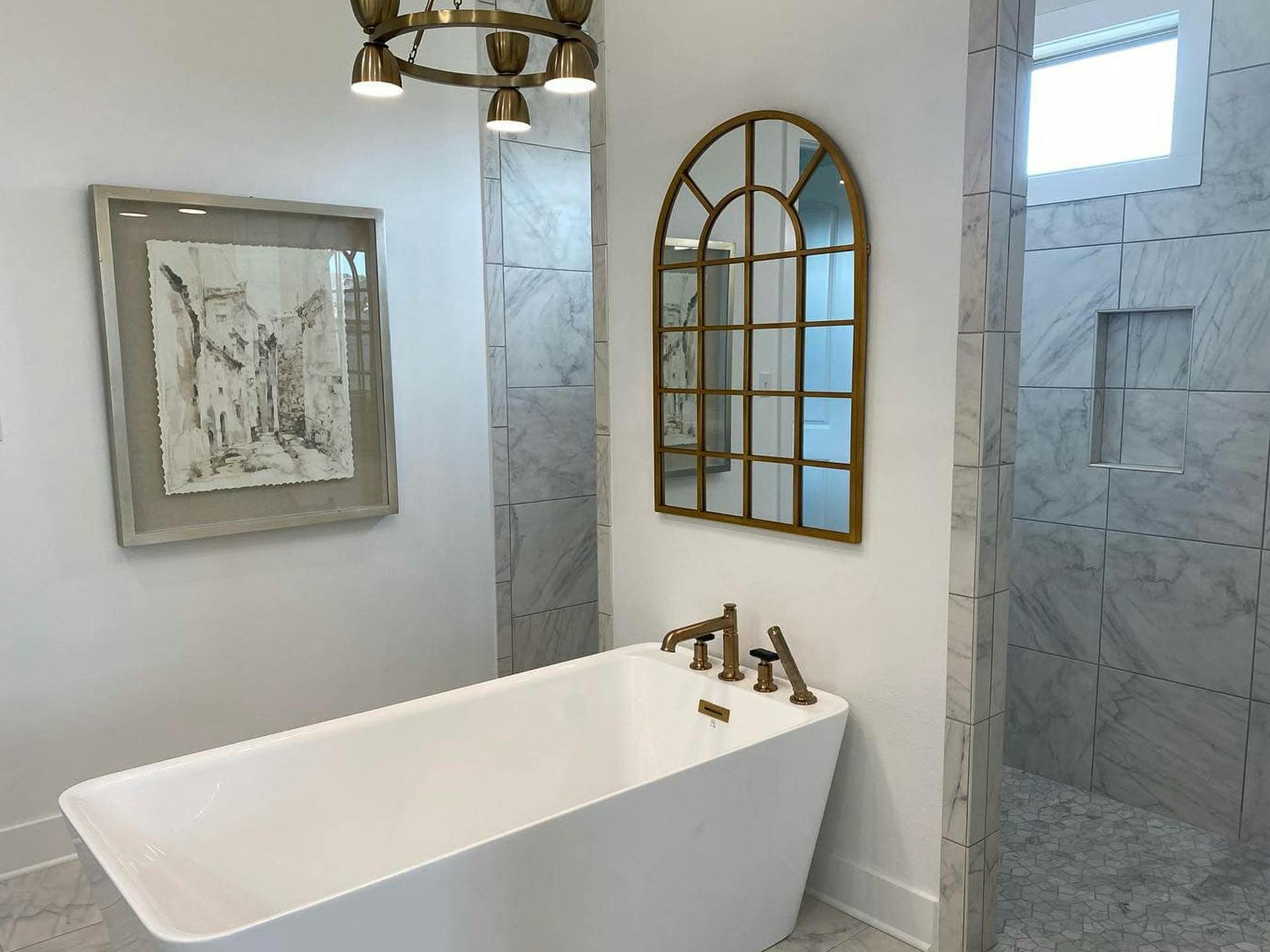 Tub in bathroom and Kichler chandelier hanging overhead