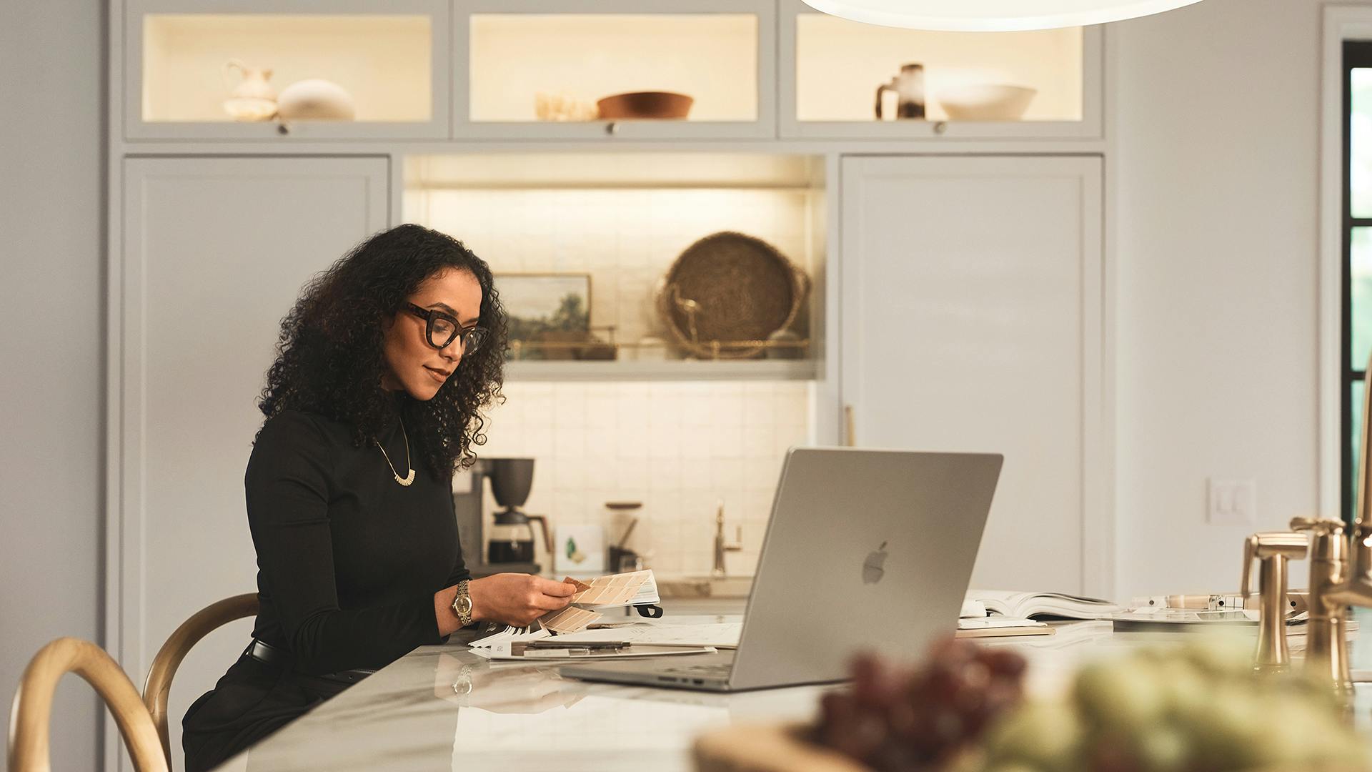 Woman working on her laptop at the kitchen counter