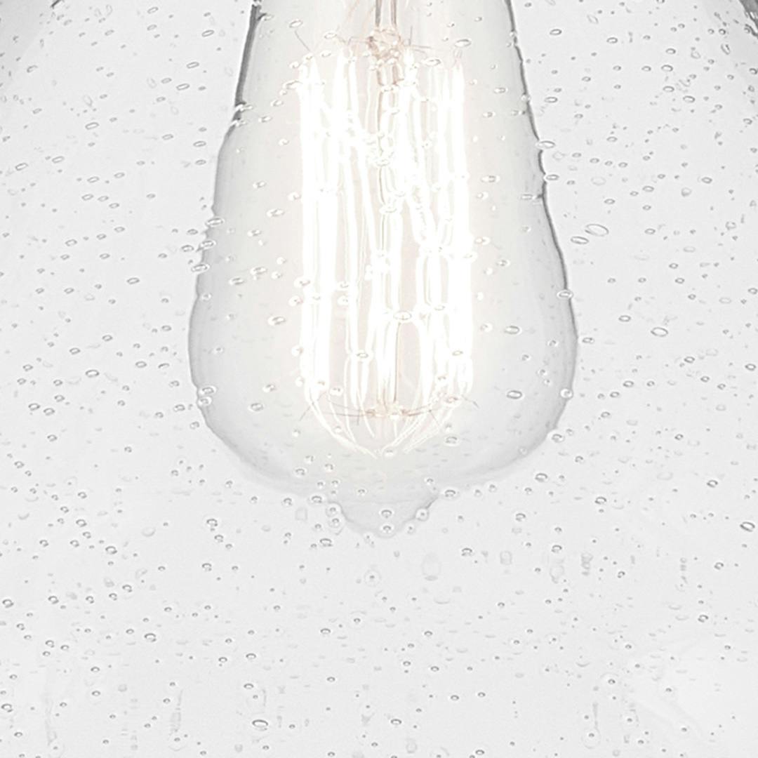 Close up view of the Avery 11.75" 1-Light Cone Pendant with Clear Seeded Glass in Natural Brass on a white background