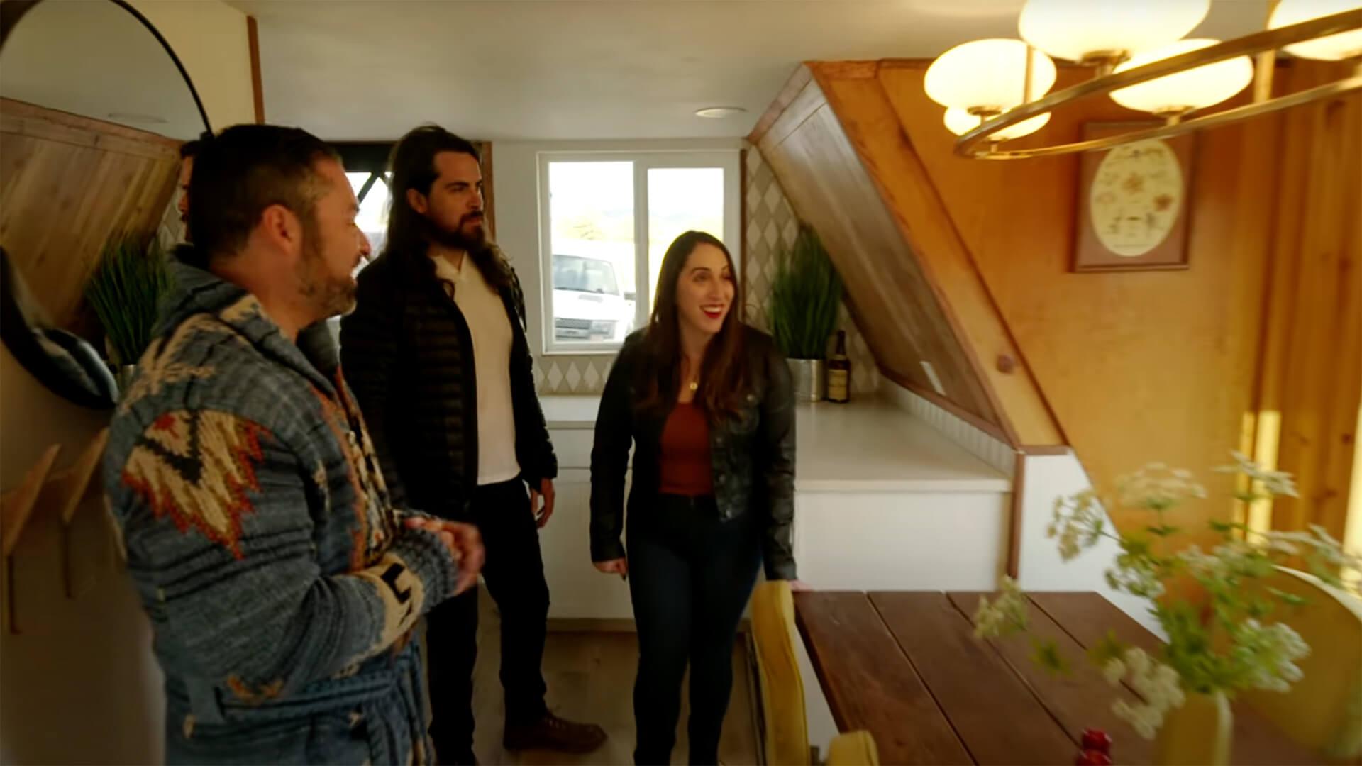 Three people in home candidly smiling at a chandelier