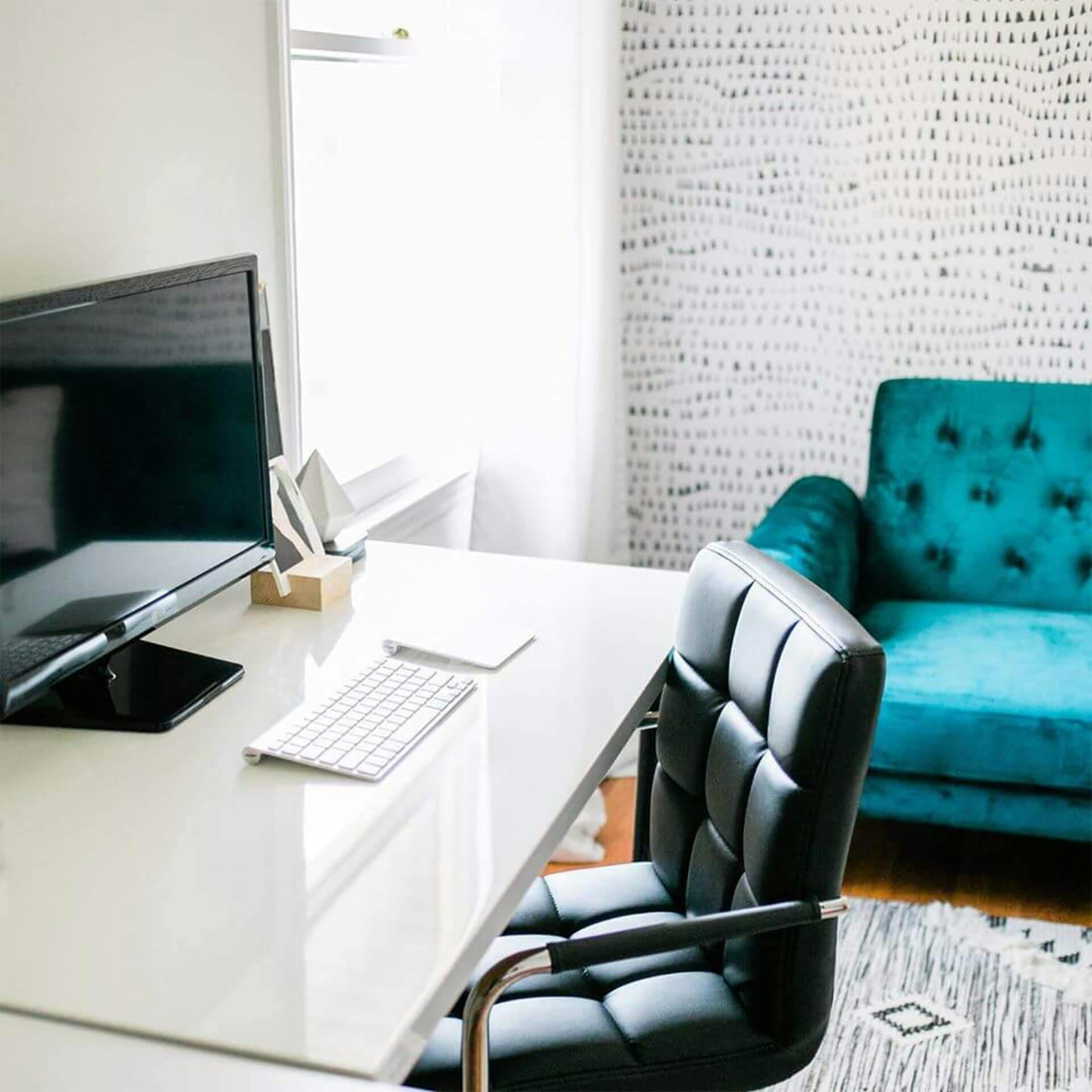 Home office with clean white desk and bright daylight pouring in