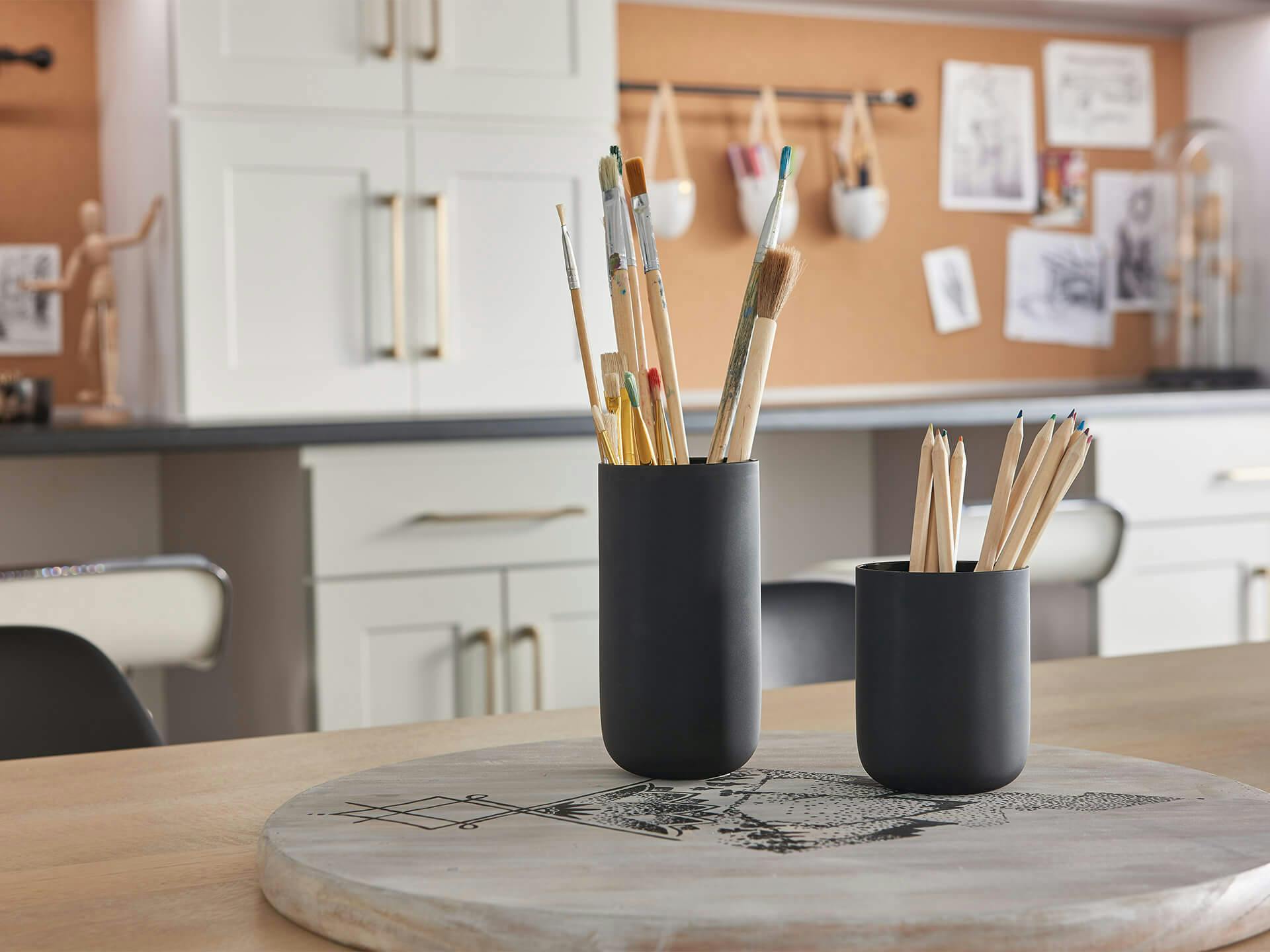 Close-up on cups of paint brushes in an office