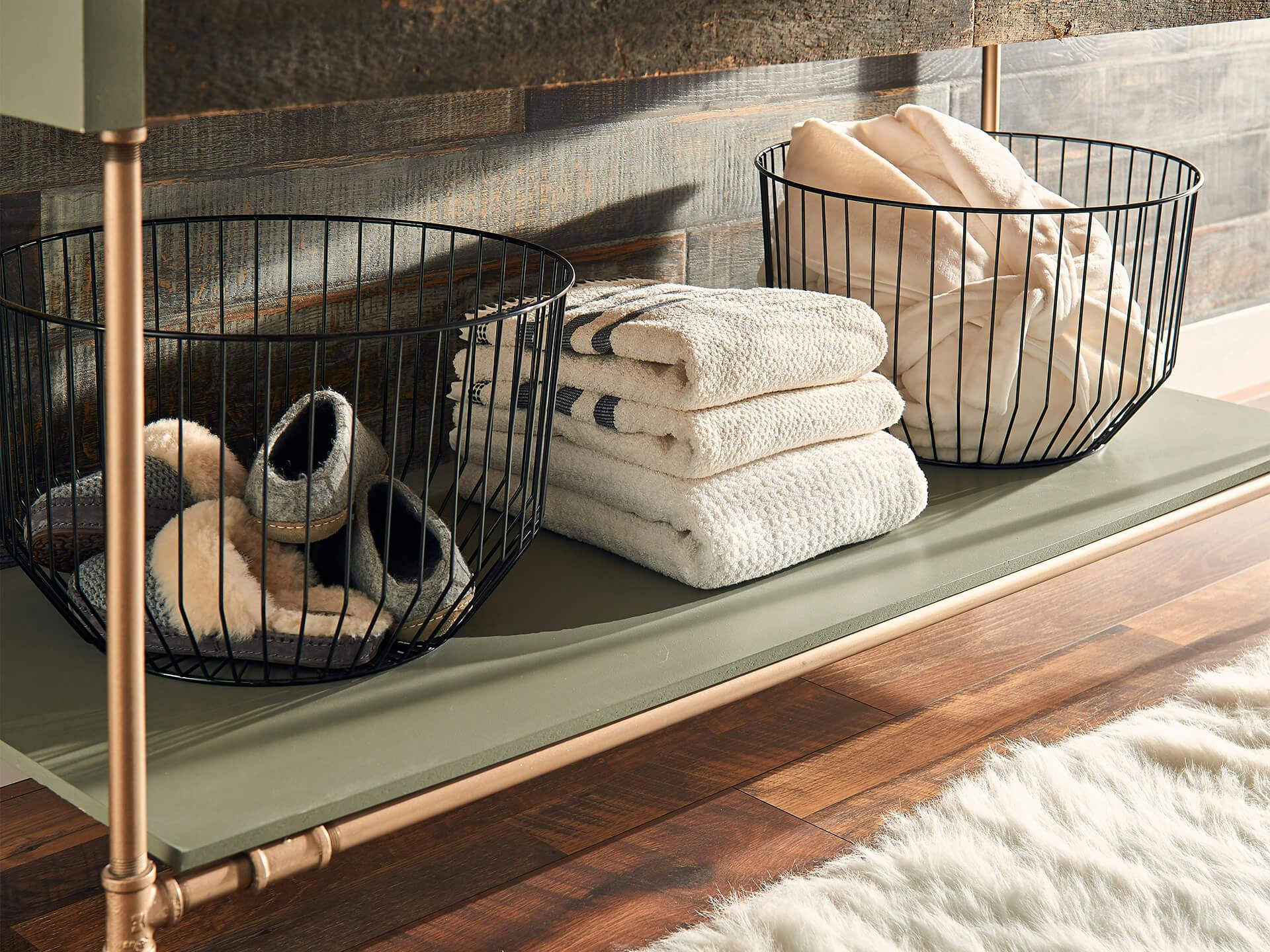 Decorative metal storage baskets and towels stored under sink