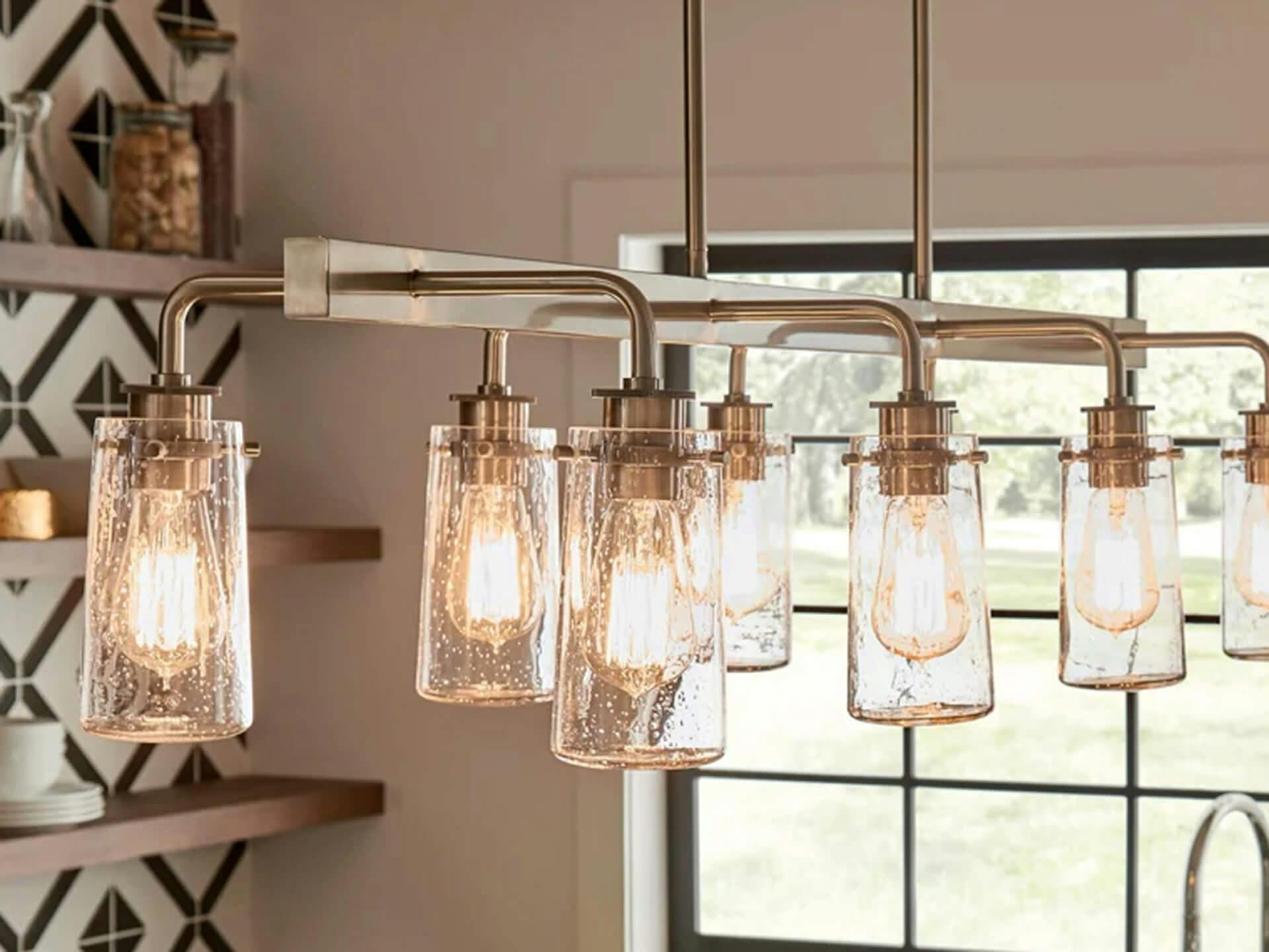 Close up of a Braelyn chandelier in a kitchen during the day with warm vintage style light bulbs