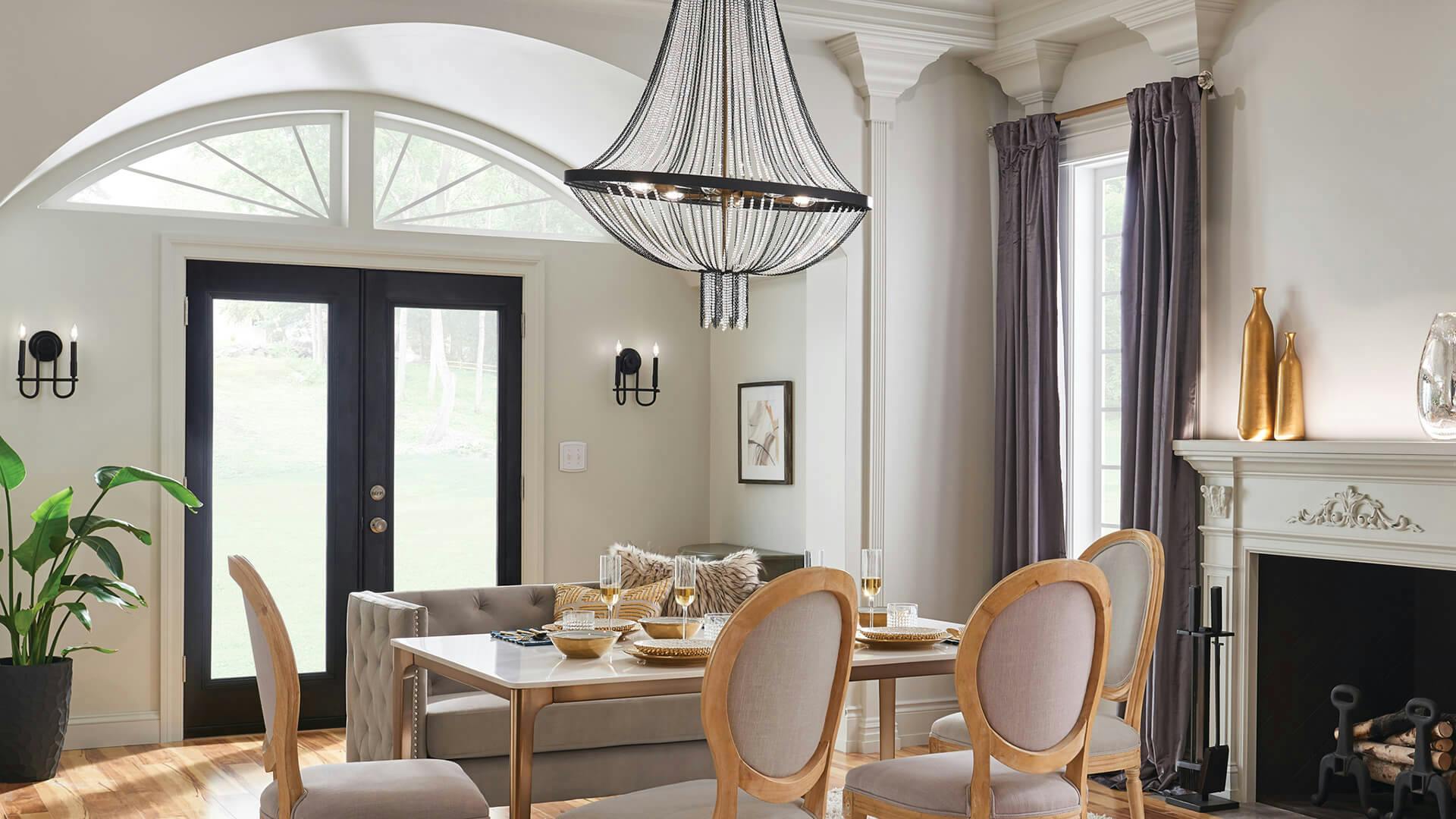 Living room with fireplace and featuring an Alexia chandelier above a large table and couch.