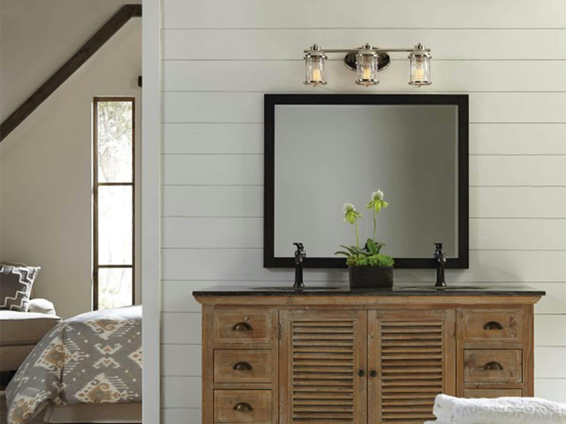 3 light Ashlandbay vanity light above a mirror and bathroom sink turned on in the daytime